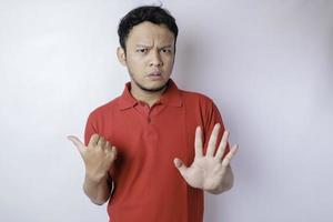 homme asiatique séduisant avec un geste de la main pose le rejet ou l'interdiction tout en pointant vers l'espace de copie à ses côtés photo