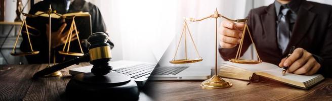 concept de justice et de droit. juge masculin dans une salle d'audience avec le marteau, travaillant avec, clavier d'ordinateur et d'accueil, lunettes, sur table à la lumière du matin photo