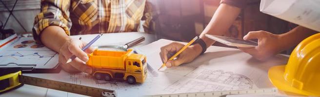 Deux collègues discutant des données de travail et tablette, ordinateur portable avec sur le projet architectural sur le chantier de construction au bureau au bureau photo