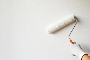 le peintre peint le mur intérieur en blanc photo