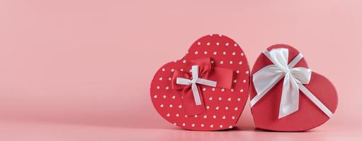 bannière avec une boîte-cadeau en forme de coeur sur fond rose. concept de cadeau de saint valentin, large bannière avec un espace pour le texte. concept - promotion, vente, shopping photo