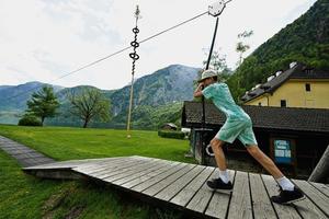 garçon se balançant sur une corde au terrain de jeu hallstatt, autriche. photo