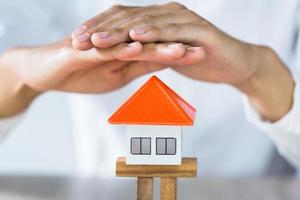 maison de protection des mains de femme, risque d'investissement et incertitude sur le marché immobilier immobilier, assurance. photo