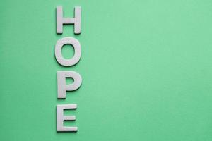 mot d'espoir avec des lettres en bois sur le fond vert photo