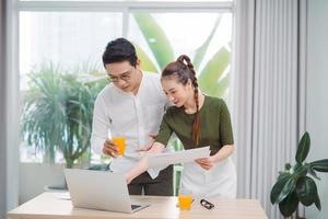 beau jeune couple au bureau, utilisant un ordinateur portable photo