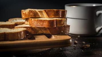 pain pour le petit déjeuner, avec une tasse de café sur fond de bois rustique avec espace de copie. petit déjeuner du matin avec café et toasts. photo
