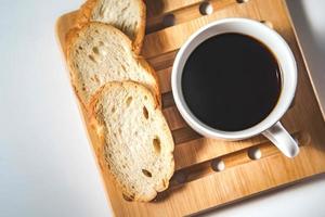 pain pour le petit déjeuner, avec une tasse de café sur fond de bois rustique avec espace de copie. petit déjeuner du matin avec café et toasts. photo