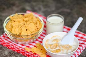 cornflakes bol petit-déjeuner et collation pour un concept d'alimentation saine, petit-déjeuner matinal céréales complètes fraîches, cornflakes avec du lait sur fond sombre photo