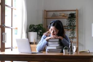 femme asiatique souriante utilisant un casque regardant un écran d'ordinateur portable écouter et apprendre des cours en ligne avec un appel vidéo avec un casque pour l'apprentissage en ligne photo