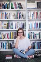 Étudiante célèbre lisant un livre à la bibliothèque photo