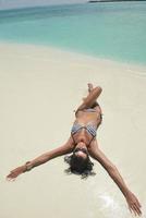 belle jeune femme sur la plage s'amuser et se détendre photo