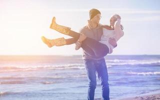 jeune couple aimant sur une plage à la journée ensoleillée d'automne photo