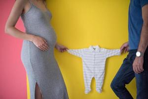 jeune couple tenant des combinaisons de bébé photo