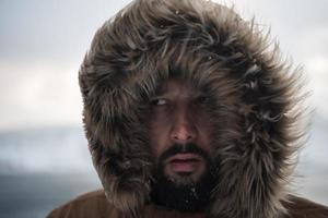 homme en hiver par temps orageux portant une veste de fourrure chaude photo