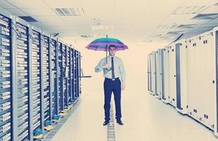 un homme d'affaires tient un parapluie dans la salle des serveurs photo