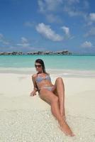 belle jeune femme sur la plage s'amuser et se détendre photo