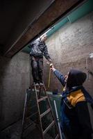 ouvriers du bâtiment installant une fenêtre de toit photo