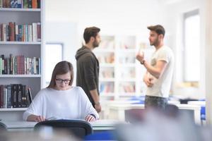 étude étudiante dans la bibliothèque de l'école, groupe d'étudiants en arrière-plan photo