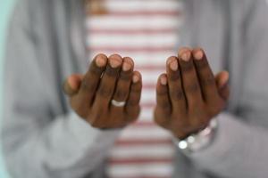 jeune homme musulman africain faisant la prière traditionnelle de fatiha à allah photo