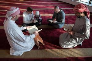 les musulmans dans la mosquée lisant le coran ensemble photo