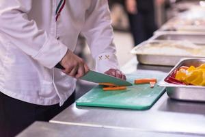 mains de chef coupant des légumes frais et délicieux photo