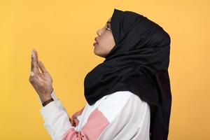 la femme musulmane africaine fait la prière traditionnelle à dieu, garde les mains dans le geste de prière, porte des vêtements blancs traditionnels photo