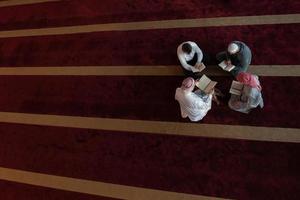 les musulmans dans la mosquée lisant le coran ensemble photo