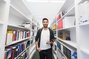 étudiant avec tablette dans la bibliothèque photo