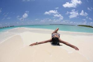 belle jeune femme sur la plage s'amuser et se détendre photo