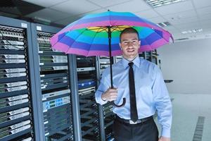 un homme d'affaires tient un parapluie dans la salle des serveurs photo