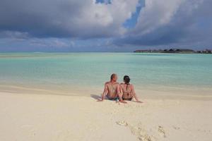 heureux jeune couple en vacances d'été s'amuser et se détendre à la plage photo