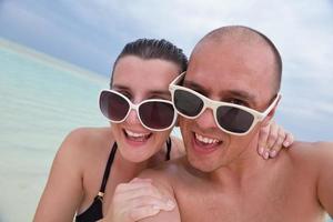 heureux jeune couple en vacances d'été s'amuser et se détendre à la plage photo