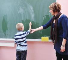 heureux jeune garçon aux cours de mathématiques de première année photo