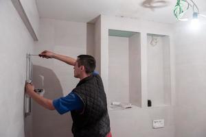 plombier professionnel travaillant dans une salle de bain photo