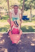 mère et fille se balançant dans le parc photo