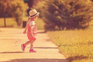 petite fille qui court dans le parc d'été photo