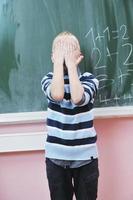 heureux jeune garçon aux cours de mathématiques de première année photo