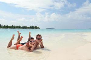 heureux jeune couple s'amuser sur la plage photo