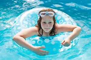 fille sur le cercle de natation dans la piscine en plein air bleue photo