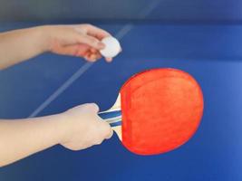 fille joue au tennis de table avec une raquette rouge photo