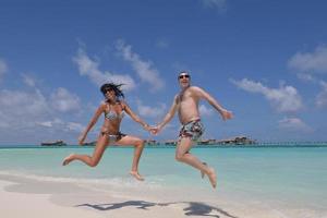 heureux jeune couple s'amuser sur la plage photo