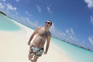 jeune homme s'amuser et se détendre sur la plage photo