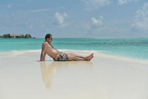 belle jeune femme sur la plage s'amuser et se détendre photo