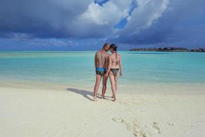 heureux jeune couple en vacances d'été s'amuser et se détendre à la plage photo