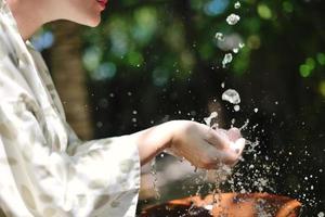 éclabousser de l'eau douce sur les mains de la femme photo