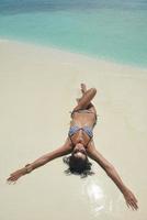 belle jeune femme sur la plage s'amuser et se détendre photo