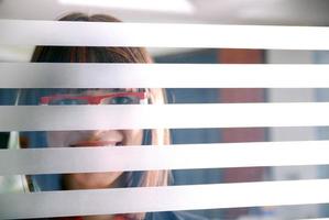 jeune femme d'affaires regardant à travers un mur transparent photo