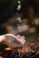 éclabousser de l'eau douce sur les mains de la femme photo