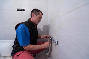 plombier professionnel travaillant dans une salle de bain photo