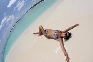 belle jeune femme sur la plage s'amuser et se détendre photo